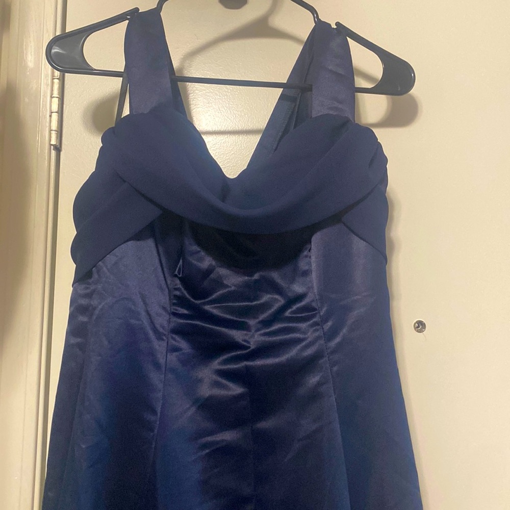 A navy blue ball gown has a bow in the back